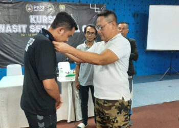 Kadisbudparpora sedang menyeematkan tanda peserta kursus wasit C3 Kabupaten Sumedang