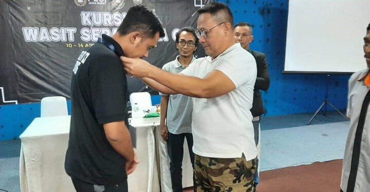 Kadisbudparpora sedang menyeematkan tanda peserta kursus wasit C3 Kabupaten Sumedang