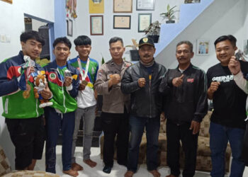 Kepala Unit (Kanit) Satuan Polisi Pamong Praja (Satpol PP) Kecamatan Cileunyi, Kabupaten Bandung, Rosyid bersama Bhabinkamtibmas Cinunuk, Aipda Heri berkunjung ke Padepokan Atlit Pornas Gulat Tradisional, Sabtu (15/7/2023).