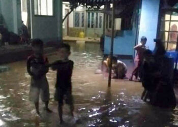 Sejumlah anak-anak di Desa Cihanjuang sedang bermain-main ditengah genangan air akibat Sungai Cimande meluap