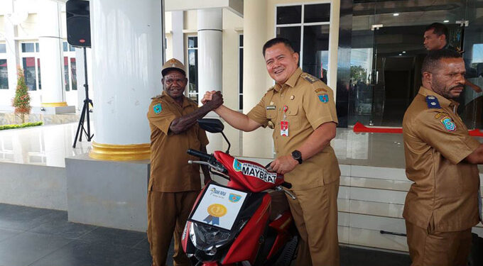Pj. Bupati Maybrat, Bernhard Edward Rondonuwu menyerahkan hadiah sepeda motor kepada pemenang lomba Hias Kampung