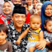Calon bupati nomor urut 2, Bayu Syahjohan berfoto bersama warga seraya menggendong dua anak