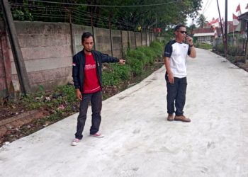 Kades Cintamulya, Sarip Wahyudi (kiri) saat meninjau jalan yang sudah diperbaiki