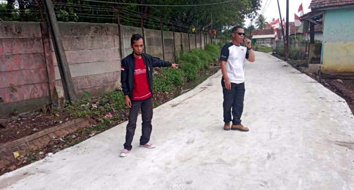 Kades Cintamulya, Sarip Wahyudi (kiri) saat meninjau jalan yang sudah diperbaiki