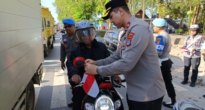 Wakapolres Tanah Bumbu, Kompol Apriyansa Sinatra, memasangkan bendera merah putih. Foto Dok Istimewa